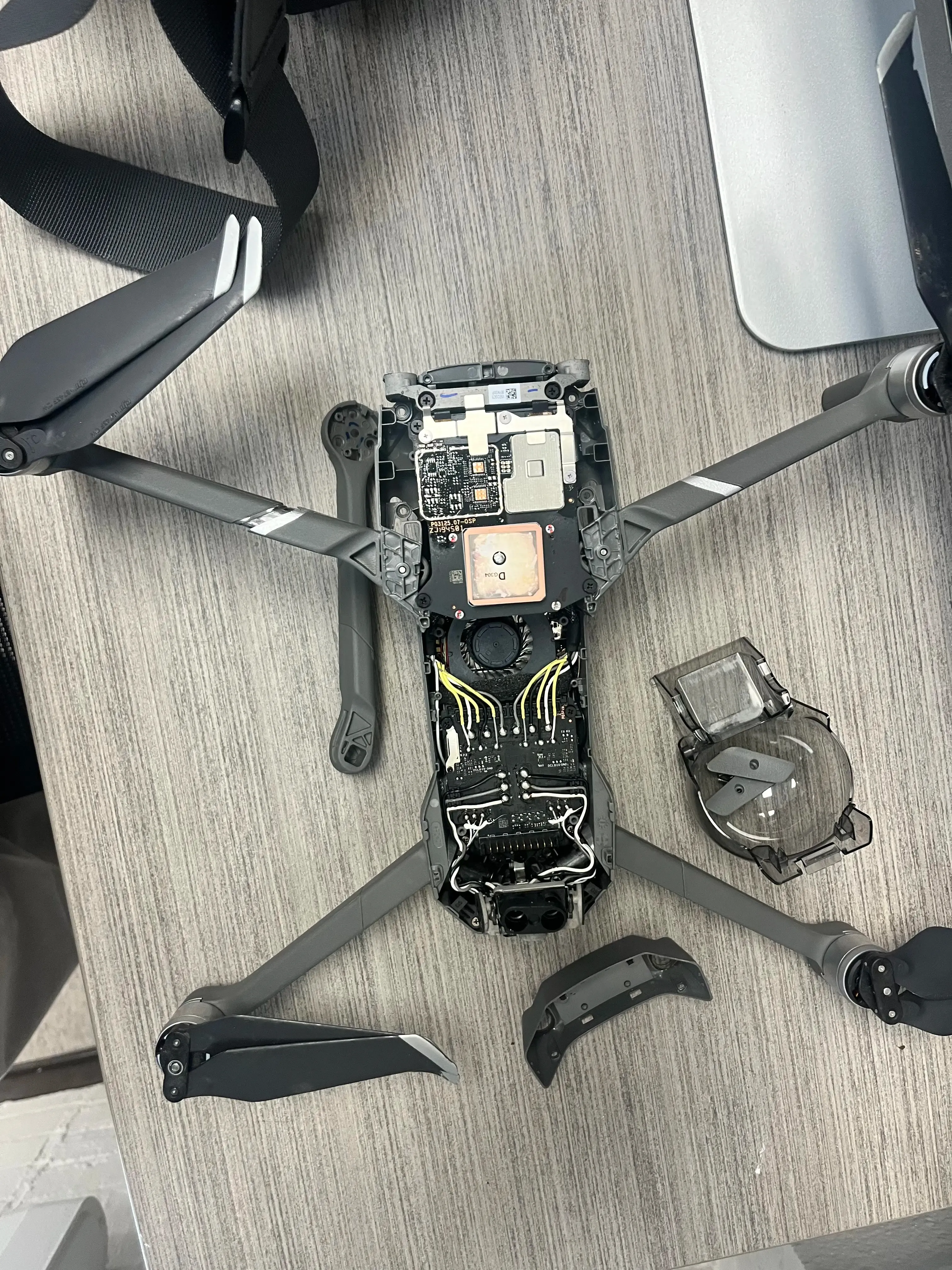 Repair work on a DJI Mavic 2 drone, disassembled on a desk